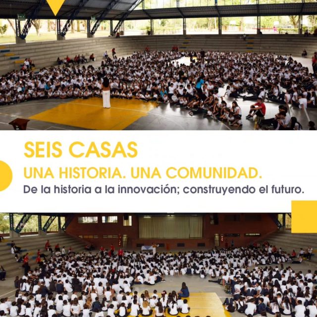 Cientos de estudiantes reunidos en un coliseo cubierto, con el mensaje «Seis casas. Una historia. Una comunidad.»